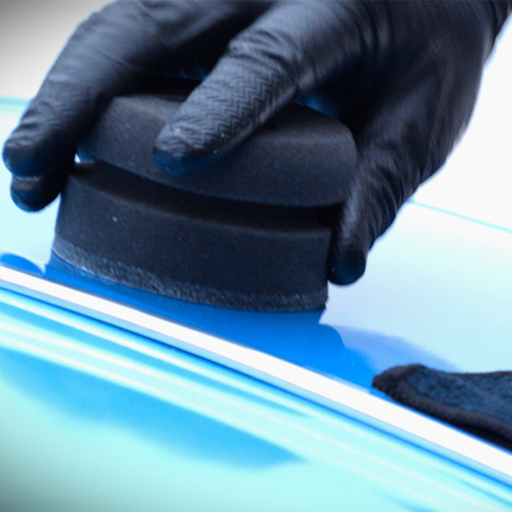 connect car wax application puck being used on blue car 